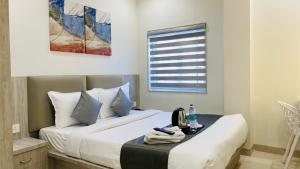 um quarto com uma cama com uma mesa e uma janela em Hotel Rex em Indore