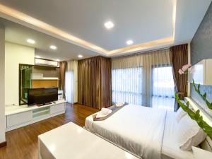 Schlafzimmer mit einem Bett und einem Flachbild-TV in der Unterkunft THE BOSS HOTEL CHIANGMAl in Chiang Mai