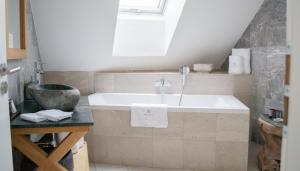 a bathroom with a tub and a sink at Resort CATTALEYA in Čeladná