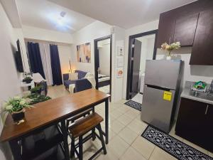 a kitchen and living room with a table and a refrigerator at 1 bedroom in Pioneer Woodlands Condo near Mrt Boni Mandaluyong in Manila