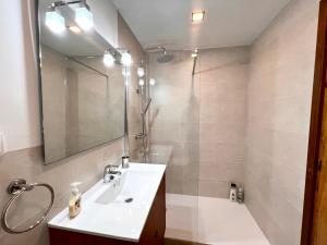 a bathroom with a sink and a shower with a mirror at Apartament Matxicots in Rialp