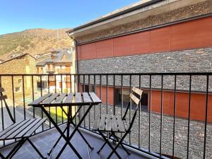 a balcony with two wooden benches and a building at Apartament Matxicots in Rialp