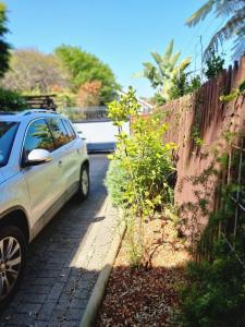 un coche aparcado junto a una valla en Sunlight Cottage en Ciudad del Cabo