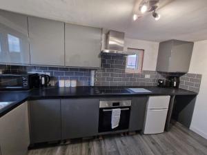 a kitchen with a black counter top and appliances at Laragh situated in the heart of Conwy County in Deganwy