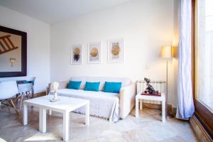 een woonkamer met een witte bank en 2 tafels bij Apartamentos Villablino Arturo Soria in Madrid