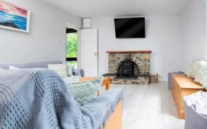 a living room with a couch and a fireplace at Ellie's Farmhouse in Ard Fhearta