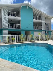 un edificio con piscina di fronte a un edificio di CARIBBEAN RESIDENCE a Sainte-Luce