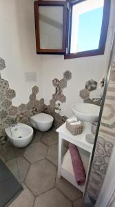 a bathroom with two sinks and two toilets at Li Petri Manni in Olbia