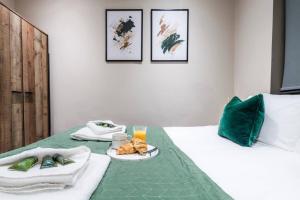 a bedroom with a bed with a green blanket and a tray of food at Wiverton Apt #1 - Central Location - Free Parking, Fast WiFi and Smart TV by Yoko Property in Nottingham