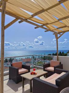 een patio met stoelen en tafels en uitzicht op de oceaan bij 3 Bedroom Coral Bay Panorama Seaview Villa Pool in Coral Bay