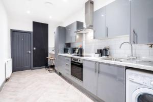 a white kitchen with a sink and a dishwasher at Wiverton Apt #1 - Central Location - Free Parking, Fast WiFi and Smart TV by Yoko Property in Nottingham