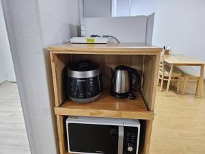 a shelf with a microwave and a coffee maker on it at BA Stay in Suwon