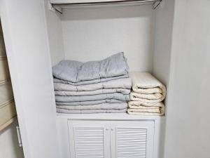 a pile of towels sitting on a shelf in a closet at BA Stay in Suwon