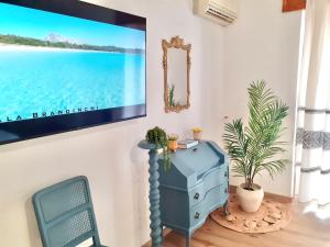sala de estar con armario azul y TV en la pared en Nuovissima Casa in Sardegna!!!!!!!, en Laerru