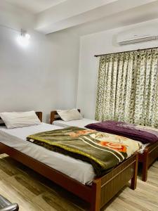 1 dormitorio con 2 camas y ventana en Hotel Sova's Inn, en Birātnagar