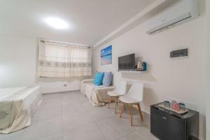 1 dormitorio con 1 cama, 2 sillas y TV en Brorent Affittacamere moro dream en Olbia