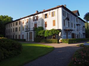 a large white building with a green yard at Vista Lago Apartment in Bellagio