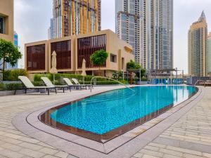 a swimming pool in a city with tall buildings at Boutique Living - Opera Grand in Dubai