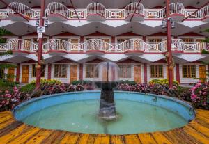 a fountain in a pool in front of a building at Kea Garden Guest House in Brinchang