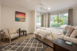 a bedroom with a bed and a chair and a window at Villa 16 @ Rivendell Winery Estate - Yallingup in Yallingup Siding