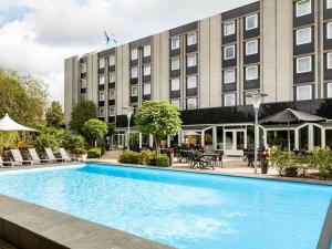 una piscina de hotel frente a un edificio en Novotel Maastricht en Maastricht