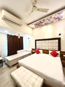 a bedroom with two beds and a ceiling fan at Hotel Gopinath The Grand in Karnāl