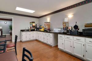 a large kitchen with white cabinets and a table at Days Inn by Wyndham Dillon in Dillon