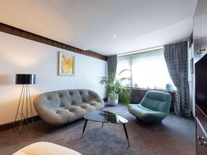 a living room with a couch and a chair at Sofitel Lyon Bellecour in Lyon