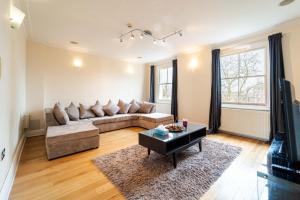 ein Wohnzimmer mit einem Sofa und einem Tisch in der Unterkunft PLACIFY Riverside Penthouse in Chelsea Near King's Road in London