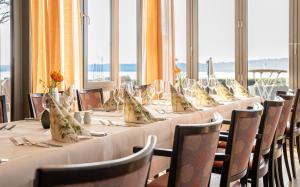 a long table with white table cloths and chairs at Hotel Seeblick in Thülsfeld