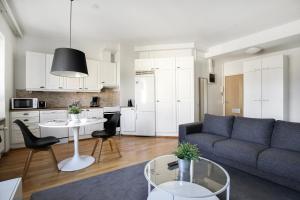 a living room with a couch and a table at Kotimaailma Apartments Kamppi - spacious 1BR in Helsinki