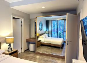 a hotel room with a bed and a mirror at The Deck Condominium by Lofty in Patong Beach