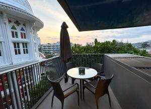a patio with a table and chairs on a balcony at The Deck Condominium by Lofty in Patong Beach