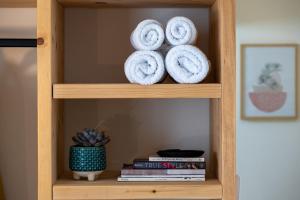a book shelf with white towels and books at Capella Town, Skiathos in Skiathos Town