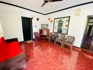 a living room with chairs and a red floor at Pool Villa of COORG in Madikeri