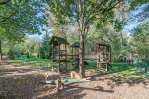 einen Park mit einem Spielplatz mit einem Baum und Schaukeln in der Unterkunft Huge Luxury House - 6 floors-6 Bedrooms- center in Warschau