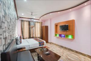 a hotel room with a bed and a table at FabHotel Deepak Palace in Varanasi