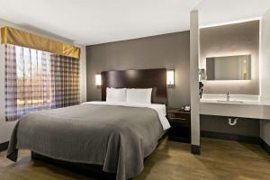 ein Hotelzimmer mit einem großen Bett und einem Waschbecken in der Unterkunft Quality Inn in Lavonia