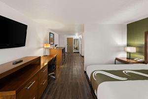 a hotel room with a bed and a flat screen tv at Quality Inn & Suites near I-480 and I-29 in Council Bluffs