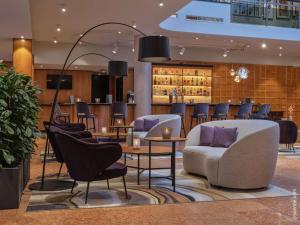 a lobby with chairs and tables and a bar at Dorint City-Hotel Salzburg in Salzburg