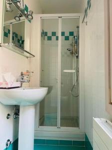 une salle de bain avec une douche en verre et un lavabo dans l'établissement Bella Ciao Old Town, à Bergame