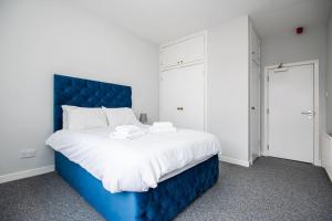 a bed with a blue headboard in a room at Bright beautiful flat in Dundee in Dundee