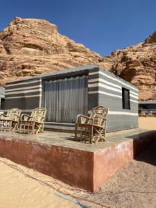 a group of chairs sitting in front of a building at Wadi Rum alsultan Camp in Wadi Rum