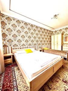 Cama grande en habitación con pared en 241 Рядом с Байтереком и красивым видом на город с 3 кроватями и 2 диванами для 1-9 чел, en Astana