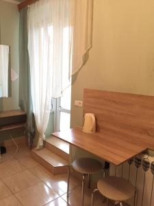 a room with a table and two stools and a window at М.Арнаутская 33 in Odesa