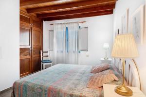 1 dormitorio con 1 cama y 1 mesa con lámpara en Apartamentos Toledo, en Caleta de Sebo