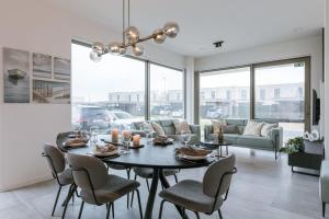 a dining room and living room with a table and chairs at Brand new pet friendly apartment with parking in Ostend