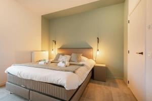 a bedroom with a large bed with towels on it at Brand new pet friendly apartment with parking in Ostend