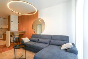 a living room with a blue couch and a mirror at Apartment Sanja in Novi Sad