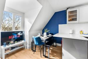 uma cozinha com uma mesa de jantar e uma parede com detalhes em azul. em The Chaucer - Stylish City Centre Gem - Sleeps 7 em Kent
